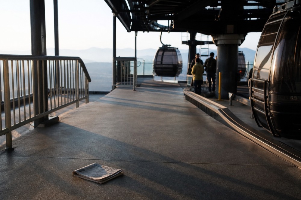 Gondola station platform in morning light with cabins arriving at the boarding area, no text, no logos, no people