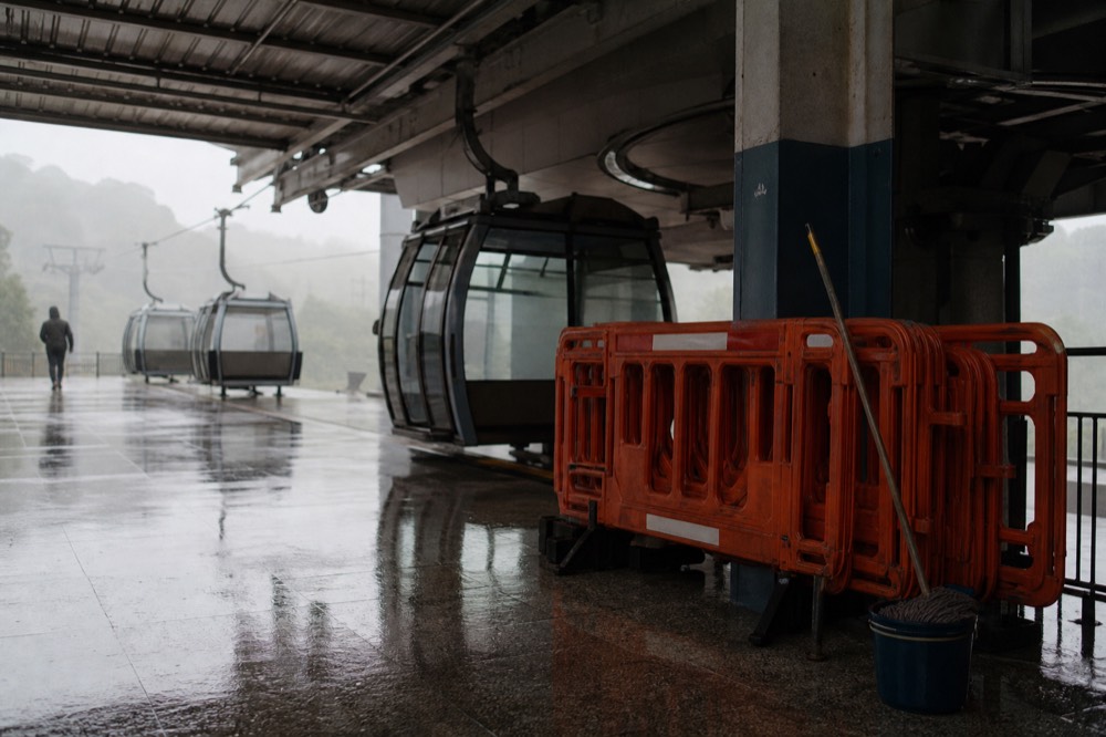 Empty gondola station platform with maintenance barriers and cabins parked offline, no text, no logos, no people