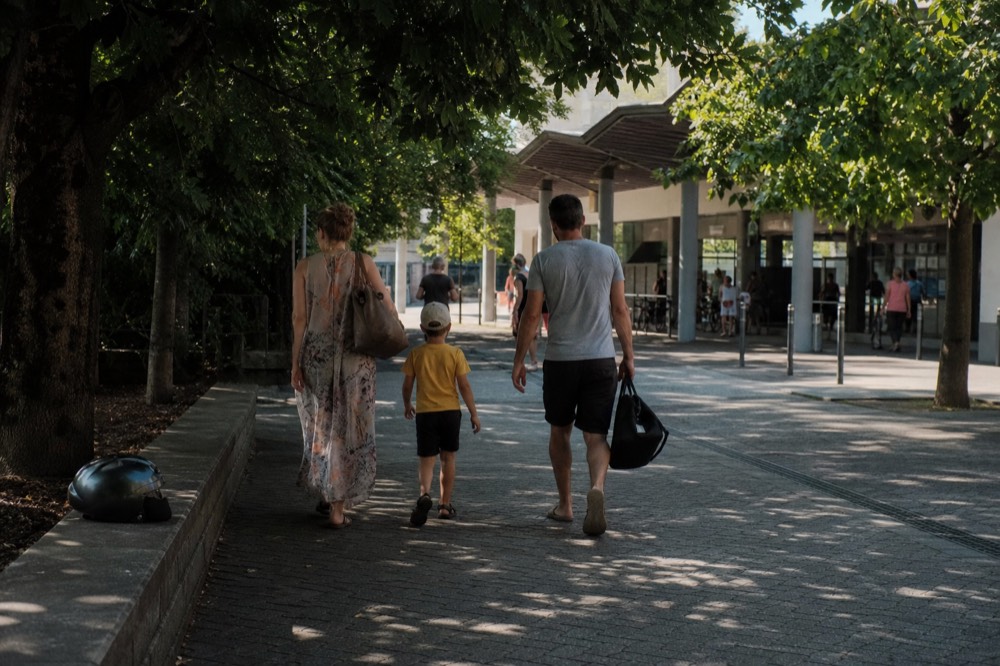 A family walking toward a gondola station entrance path, no text, no logos, no people