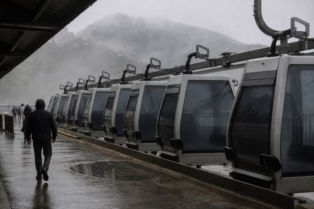 Gondola cabins parked in a station during cloudy mountain weather, no text, no logos, no people