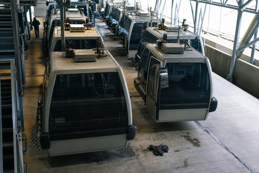 Empty gondola station platform with cabins parked in the maintenance bay, no text, no logos, no people